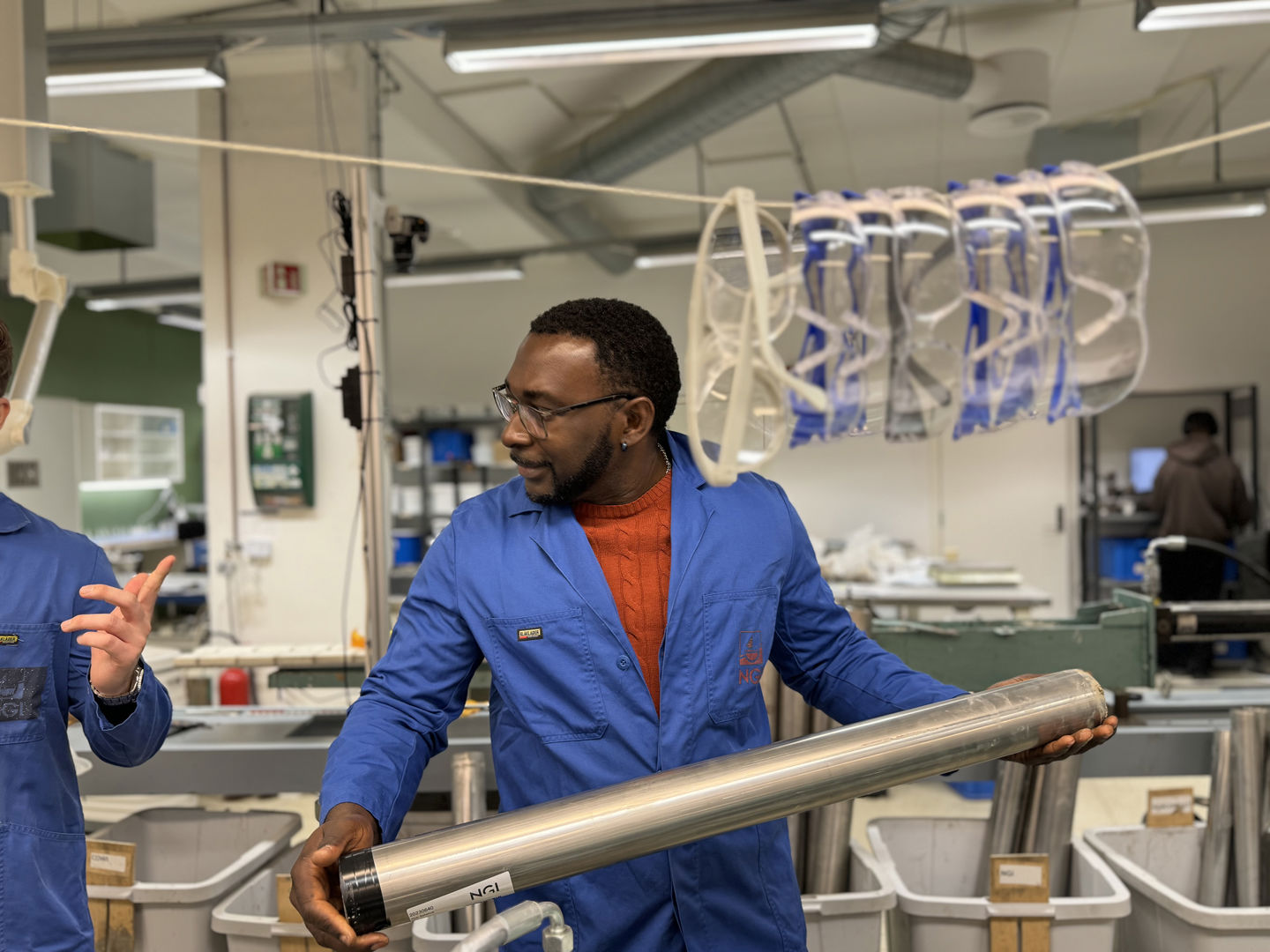 Jacob bærer et metallrør man bruker til jordprøvetaking.